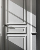 Белая классическая дверь из дерева с рельефными филенками